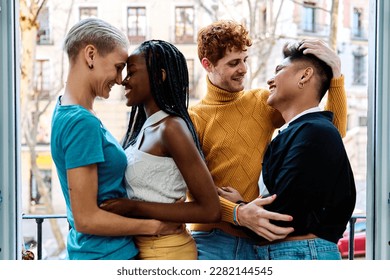 Lesbian and gay couple embracing and kissing on a balcony - Powered by Shutterstock