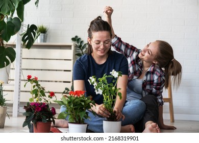 Lesbian Lgtb Couple Planting Flowers Together For Their Home.