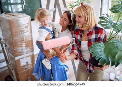 Lesbian Parents With Boxes - Young Couple Moving Into A New Home With A Toddler Girl.
