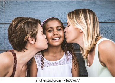 Lesbians mothers with adopted child - Happy homosexual family playing with her daughter