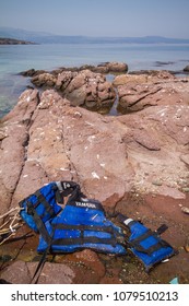 Lesbos, Greece - April 13th, 2018: A Life Vest Used By Refugees Can Be Seen On The Shore. Migrant Crisis In Lesvos