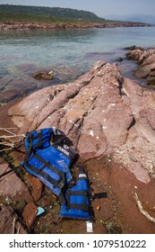 Lesbos, Greece - April 13th, 2018: A Life Vest Used By Refugees Can Be Seen On The Shore. Migrant Crisis In Lesvos