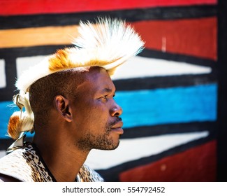 LESEDI CULTURAL VILLAGE, SOUTH AFRICA - NOVEMBER 4, 2016. Profile portrait of a young male tribal warrior wearing traditional headdress. Zulu is one of the oldest remaining tribes in South Africa.