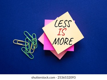 Less is More symbol. Steaky Notes with Concept words Less is More. Beautiful deep blue background. Business and Less is More concept. Copy space.