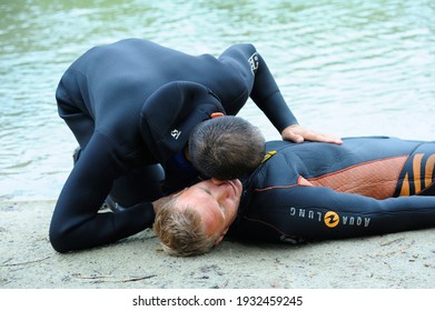 Lesson of artificial respiration. Lifeguard listening to the drowning man's breathing before giving him mouth-to-mouth resuscitation. August 10, 2018. Kiev, Ukraine