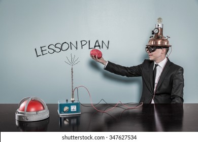 Lesson Plan Concept With Businessman Holding Brain At Hand In Office