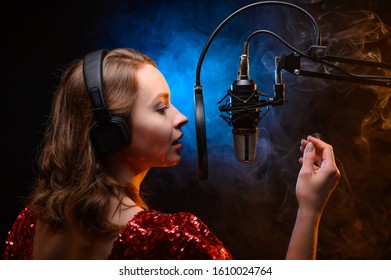 Lesson And Training In Vocal And Singing. A Girl Sings Into A Microphone, Bright Background