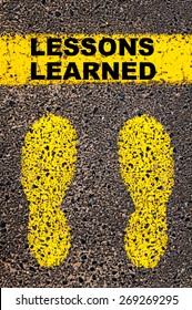 Lessons Learned  message. Conceptual image with yellow paint footsteps on the road in front of horizontal line over asphalt stone background.