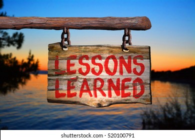 Lessons learned motivational phrase sign on old wood with blurred background