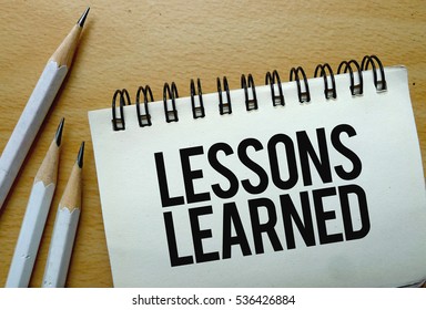 Lessons Learned text written on a notebook with pencils