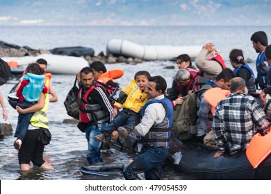 LESVOS, GREECE SEPTEMBER 24, 2015: Refugees arriving in Greece by boat from Turkey. These Syrian refugees are helped, by Norwegian volunteers, to land their boat near Molyvos, Lesvos (Mytilene).