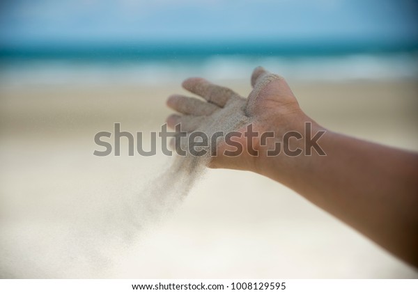 Let it go, Freedom hand , and Release concept.\
Hand let go of woman release sand on beautiful sea beach and blue\
water background