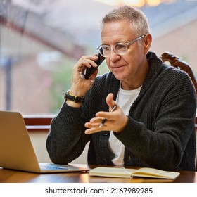 Let Me Explain. Cropped Shot Of A Handsome Senior Man Making A Phonecall While Working On His Laptop In The Study.