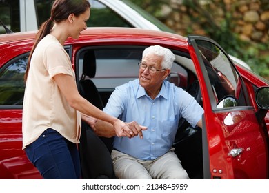 Let Me Help You Out Of The Car. Shot Of A Woman Helping Her Senior Father Out Of The Car.