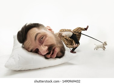 Let Me Sleep 5 Minutes More. Big Head On Small Body Lying On The Pillow. Man Can't Wake Up And Walk The Dog 'cause Has Headache And Overslept. Concept Of Business, Working, Hurrying Up, Time Limits.