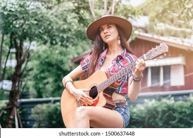 Let the music speak. Beautiful cowgirl singer perfoming outdoors. Copy space on the left side