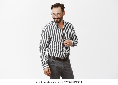 Let Us Continue Conversation In Bedroom Honey. Portrait Of Flirty Handsome Adult Man With Beard, Unbuttoning Shirt And Gazing Sensually At Camera, Hinting And Foreplaying With Mistress Over Grey Wall