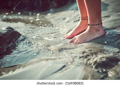 Let the water touch your toes and reach your soul. Cropped shot of an unrecognizable woman at the beach.