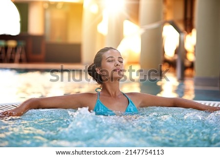 Let your mind drift. Shot of a young woman relaxing in a jacuzzi.