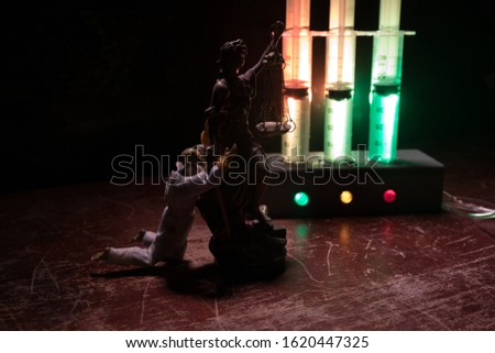 Lethal injection concept. Prisoner handcuffed to death by lethal injection. Creative artwork decoration with scale model on dark with lights.