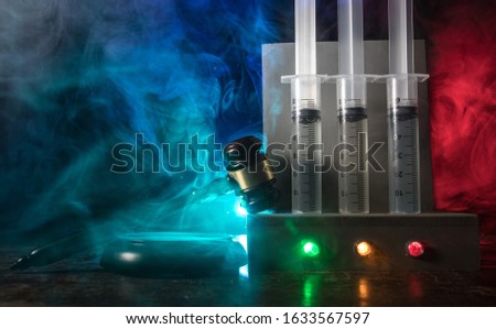 Lethal injection concept. Prisoner handcuffed to death by lethal injection. Creative artwork decoration with scale model on dark with lights.