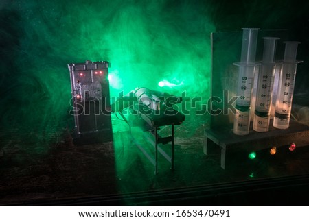 Lethal injection concept. Prisoner handcuffed to death by lethal injection. Creative artwork decoration with scale model on dark with lights.