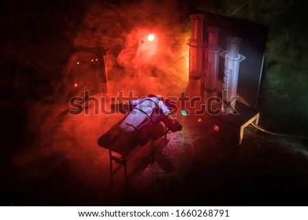 Lethal injection concept. Prisoner handcuffed to death by lethal injection. Creative artwork decoration with scale model on dark with lights.