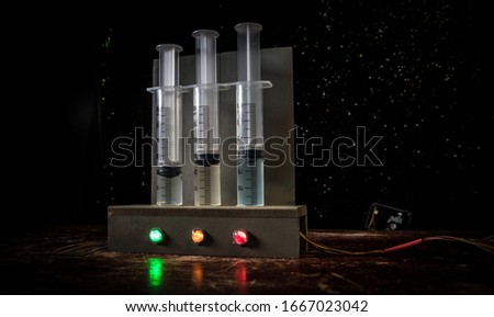 Lethal injection concept. Prisoner handcuffed to death by lethal injection. Creative artwork decoration with scale model on dark with lights.
