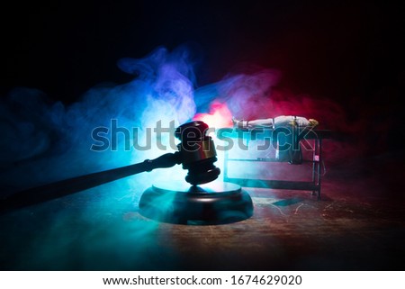 Lethal injection concept. Prisoner handcuffed to death by lethal injection. Creative artwork decoration with scale model on dark with lights.