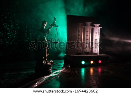 Lethal injection concept. Prisoner handcuffed to death by lethal injection. Creative artwork decoration with scale model on dark with lights.