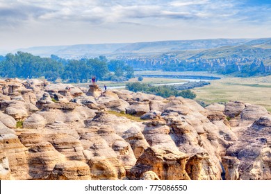 LETHBRIDGE, CANADA - AUG 22, 2016: Visitors pose for pictures on top of the hoodoos at Writing-on-Stone Provincial Park in Alberta, Canada. 