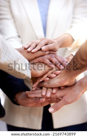 Lets all show our support. Shot of a group of unrecognizable businesspeople stacking their hands.