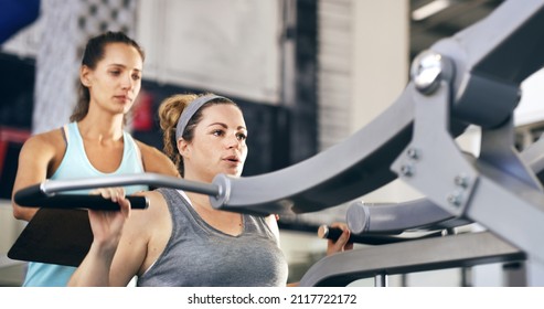 Lets begin.... Cropped shot of a female fitness instructor taking her client through a workout in the gym. - Powered by Shutterstock