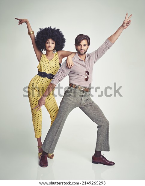 Lets dance. An attractive young couple standing\
together in retro 70s\
clothing.