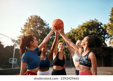 Lets do this, girls. Cropped shot of a diverse group of sportswomen holding a basketball together before playing a game during the day. - Powered by Shutterstock