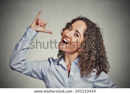Let's drink hand gesture. Portrait happy silly goofy woman gesturing showing with hand thumb to go out party get drunk isolated grey background. Positive human emotion face expression body language