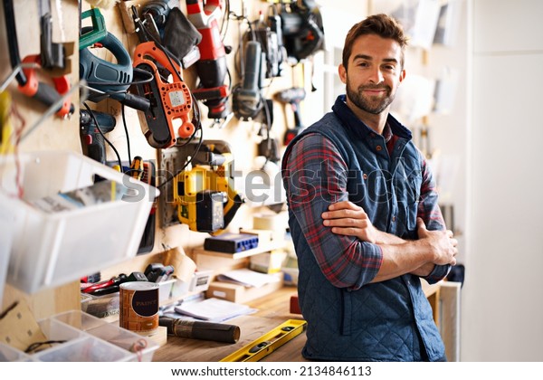 Lets fix it. Portrait of a handsome young
handyman standing in front of his work
tools.