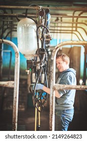 Lets Get Ready To Milk. Shot Of A Farmer Preparing The Cow Milking Equipment On A Dairy Farm.