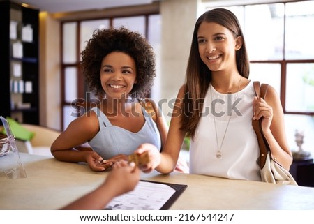 Lets get the spa day started. Shot of two friends checking in to a day spa.