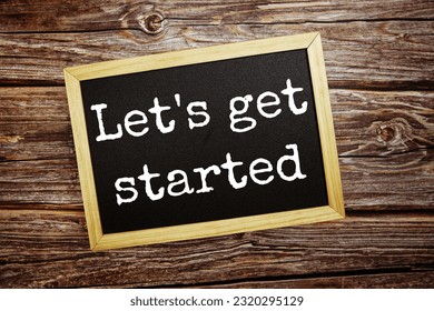 Let's get started  write on blackboard top view on wooden background
