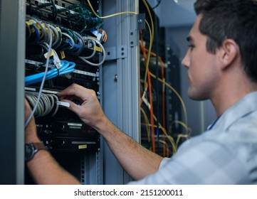 Lets get technical. Cropped shot of a handsome young male programmer working in a server room.