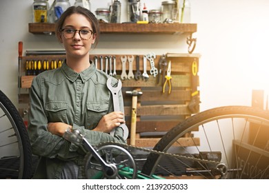 Lets Get Your Bike Back To Brand New Again. Portrait Of A Confident Young Woman Working In A Bicycle Repair Shop.