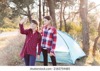 Lets Go Camping. Family Camping. Reach Destination Place. Cheerful Teenage Girls Taking A Selfie While Looking At The Phone Screen In The Middle Of A Pine Forest. Hiking Outdoor Adventure.