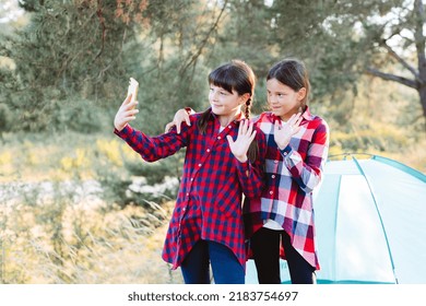 Lets Go Camping. Family Camping. Reach Destination Place. Cheerful Teenage Girls Talking On A Video Call, Looking At The Phone Screen In The Middle Of A Pine Forest Near Tent.