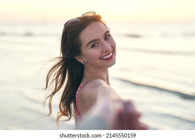 Lets Go Forth Into The Sea And Be Free. POV Shot Of A Beautiful Young Woman Holding Her Best Friends Hand At The Beach.