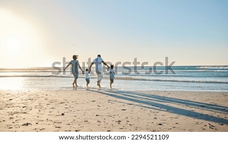 Lets go splish and splash. Rearview shot of a happy family walking towards the sea.