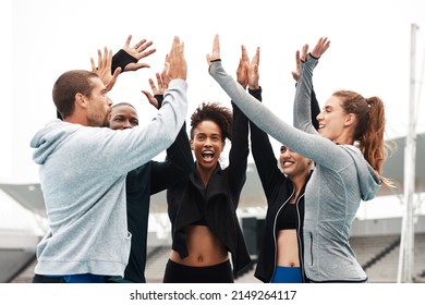 Lets Go Team. Cropped Shot Of A Diverse Group Of Athletes Standing And Giving Each Other A High Five After A Track Session.