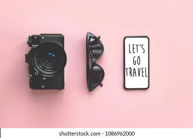 Let's Go Travel Text On Stylish Black Smartphone  Screen,sunglasses, Photo Camera On Pink Background. Stylish Summer Vacation Flat Lay. Time To Travel