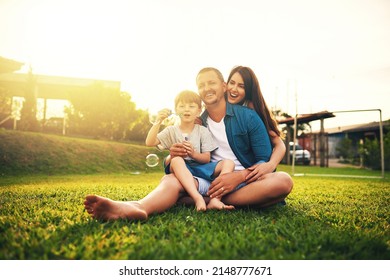 Lets have a blowing bubbles competition. Shot of a young family spending the day in the backyard. - Powered by Shutterstock