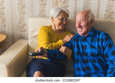 Let's Hear The News - Lovely Senior Couple On The Sofa Watching TV Senior People Support Concept Medium Shot Living Room . High Quality Photo